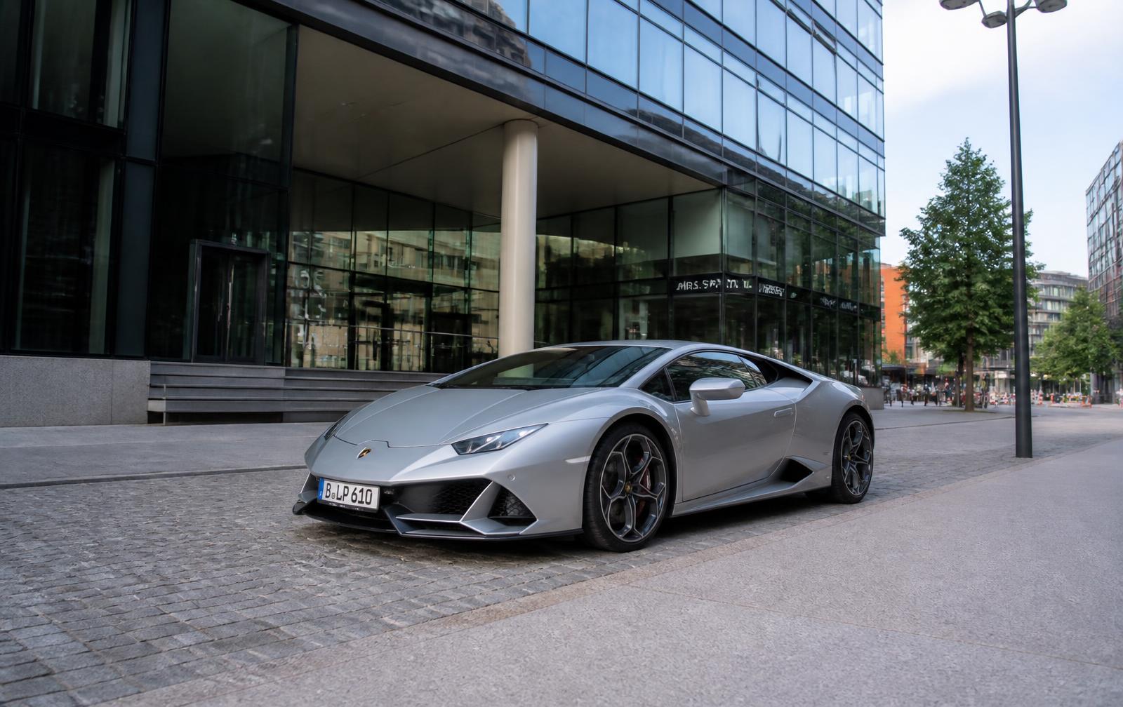 Silberner Lamborghini Huracán vor einem modernen Bürogebäude in Berlin